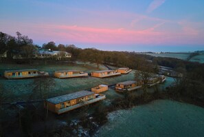 Een groep moderne cabins met uitzicht op water en bomen.