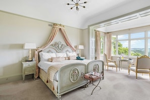A bedroom with a four-poster bed, a nightstand, a chair, and a table. - The Mole Resort (Umberleigh)
