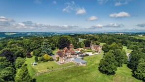 An aerial view of a large estate with a main house, multiple outbuildings, and extensive green lawns. - The Mole Resort (Umberleigh)