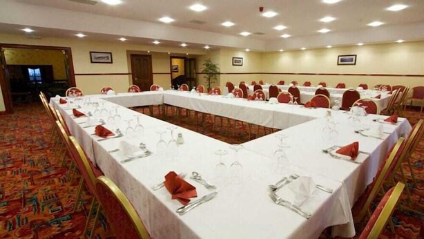 A conference room with a long table set for a meeting, surrounded by chairs. - Ayre Hotel (Kirkwall)