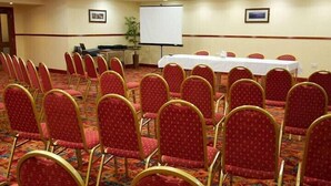 A conference room with rows of red chairs, a whiteboard, and a projector screen. - Ayre Hotel (Kirkwall)