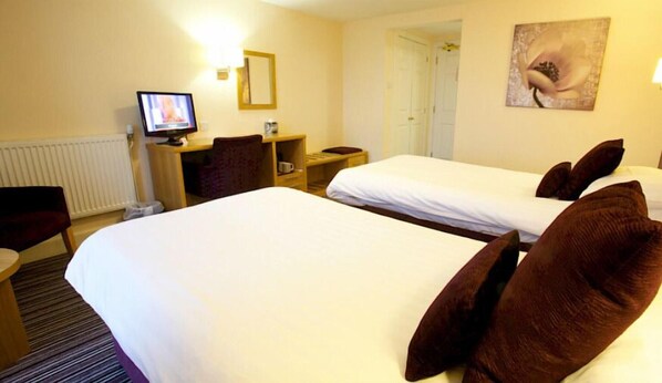 A hotel room with two beds, a desk with a computer, a chair, and a painting on the wall. - Ayre Hotel (Kirkwall)
