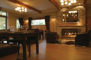 Uma sala de estar aconchegante com lareira, móveis de madeira e um candelabro.