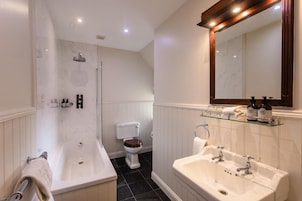 Un baño moderno con bañera, lavamanos, inodoro y ducha.