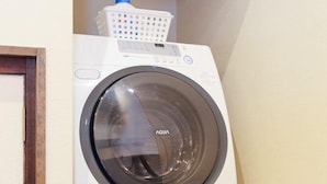 A front-loading white washing machine with a front control panel and a transparent door. - Kanazawa no Yado Ikedaya [vr] (Kanazawa)