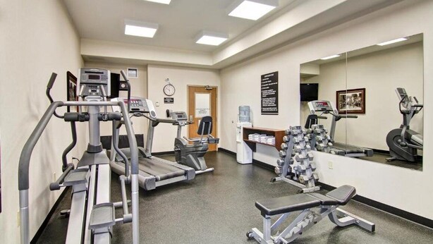 A gym with treadmills, weight machines, and a bench. - Weyburn Canalta Hotel (Weyburn)