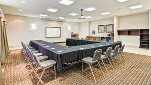 A conference room with a long table, chairs, a projector, and a whiteboard. - Weyburn Canalta Hotel (Weyburn)