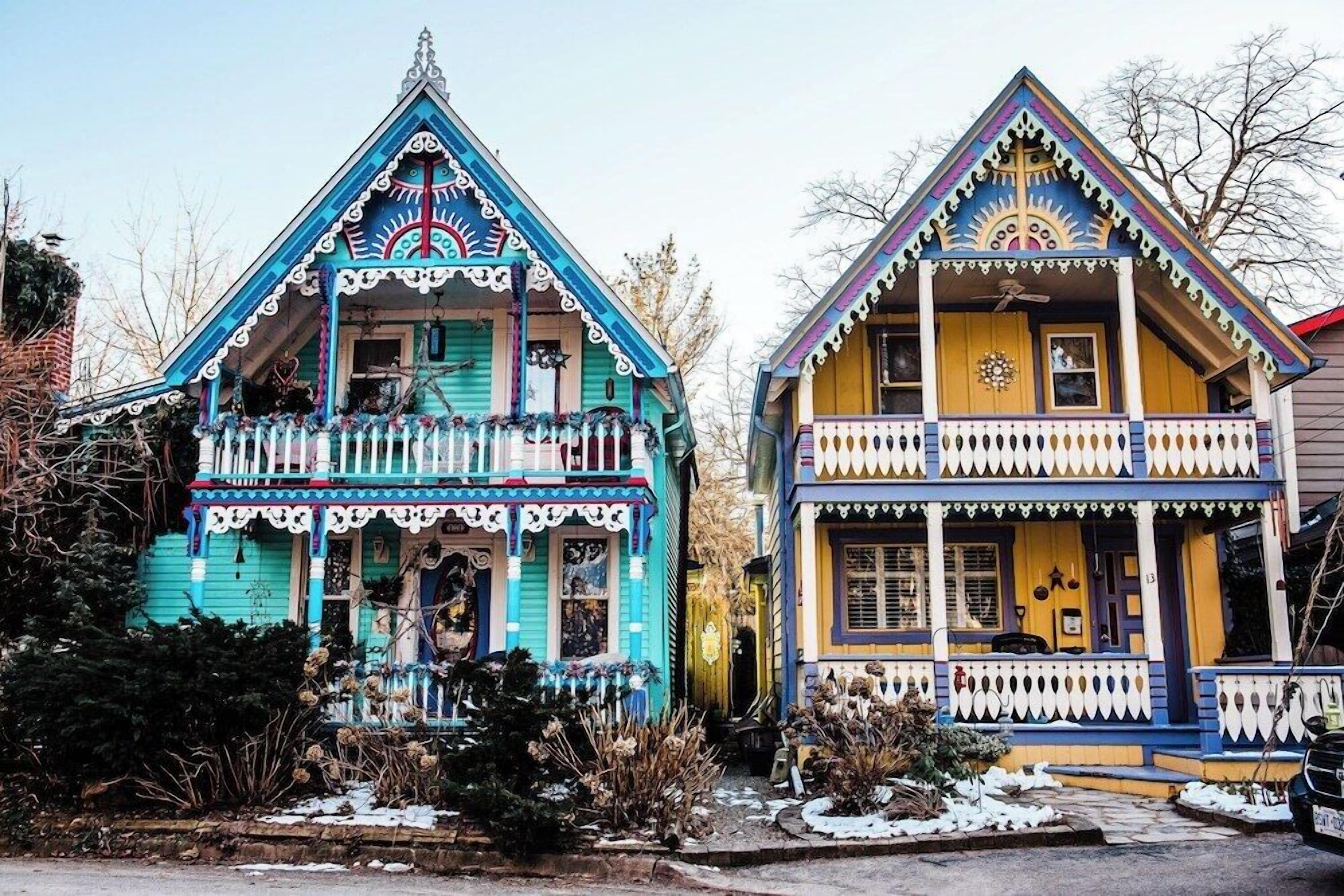 Two colorful houses with distinct architectural styles, featuring decorative elements and balconies.