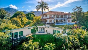 A large, two-story house with a swimming pool, surrounded by lush greenery and mountains in the background. - El Castillo - Adults Only (Ciudad Cortés)