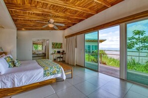 A bedroom with a wooden ceiling, a bed, a desk, and a view of the ocean. - El Castillo - Adults Only (Ciudad Cortés)