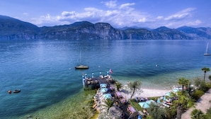 Un resort frente al lago con aguas cristalinas, un muelle y una zona de playa.