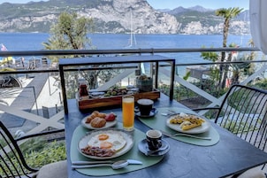 A table set for breakfast with a view of the sea and mountains.