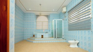 A bathroom with a shower, a sink, and a toilet. - Tamarind Guesthouse and Suites (Accra)