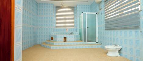 Un baño con ducha, lavamanos e inodoro.