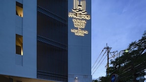A modern hotel building with a prominent sign for Okinawa Hinode Resort & Hot Spring Hotel. - Okinawa Hinode Resort And Hot Spring Hotel (Naha)