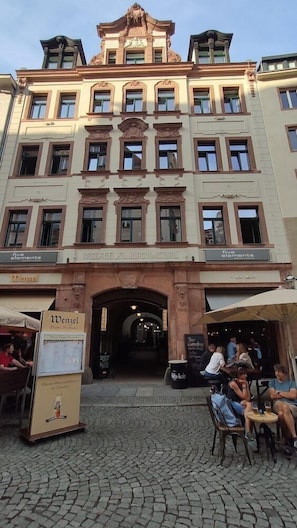 A historic building with a central entrance, multiple windows, and a sign for 'Wenzel' on the ground floor. - Say Cheese Leipzig Hotel and Hostel (Leipzig)