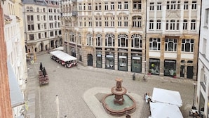 A historic square with cobblestone pavement, a central fountain, and surrounding buildings with commercial establishments. - Say Cheese Leipzig Hotel and Hostel (Leipzig)