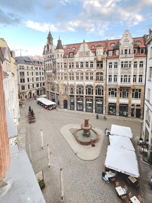 A historic square with cobblestone pavement, a central fountain, and surrounding buildings with commercial establishments. - Say Cheese Leipzig Hotel and Hostel (Leipzig)