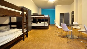 A dormitory room with bunk beds, a small table, and chairs. - Say Cheese Leipzig Hotel and Hostel (Leipzig)