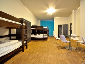 A dormitory room with bunk beds, a small table, and chairs. - Say Cheese Leipzig Hotel and Hostel (Leipzig)