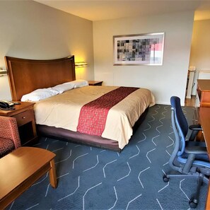 A hotel room with a bed, a desk, a chair, and a wall-mounted picture. - Travelodge Newport News (Newport News)