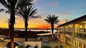 A hotel with a swimming pool, outdoor seating, and a view of the sunset. - Swai Hotel (Lake Havasu City)
