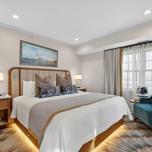 A hotel room with a large bed, a painting of a lighthouse, a window with curtains, and a small table with a vase of flowers. - Saybrook Point Inn Marina & Spa (Old Saybrook)