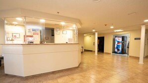 A reception area with a white counter, a no pets sign, and a fire safety sign.