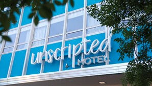 Een gebouw met een bord waarop 'unscripted HOTEL' staat.