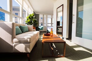 A modern living room with a sofa, a coffee table, and a large window. - Unscripted Durham (Durham)