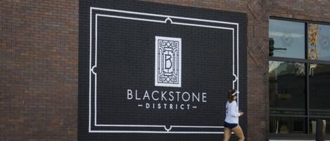 Un bâtiment en briques sur lequel est apposée une grande enseigne indiquant « QUARTIER BLACKSTONE ».