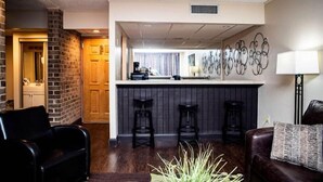 Eine moderne Hotelhalle mit Barbereich, Sitzgelegenheiten und einem Kamin.