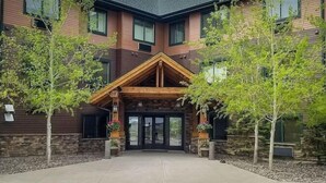 A building with a stone foundation, wooden upper floors, and a central entrance with a triangular wooden overhang.
