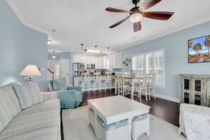 A spacious living room with a sofa, a coffee table, and a dining area with chairs and a table. - Aloha Y'all - 2nd Row in Surfside Beach! (Surfside Beach)