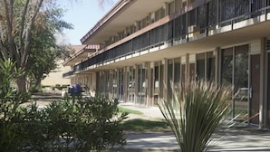 A multi-story hotel with a modern facade, large windows, and a balcony on the second floor.