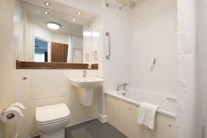 A modern bathroom with a toilet, sink, and bathtub. - Spring River by Marstons Inns (Gravesend)