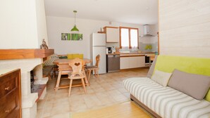 Un espacio habitable compacto con comedor, kitchenette y sofá.