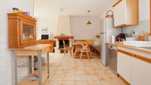 Una cocina compacta con armarios de madera, una zona de comedor con mesa y sillas, y un horno empotrado.