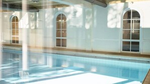 A swimming pool with clear water, surrounded by white walls and arched windows. - Interest of Bavaria (Oberstaufen)