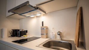Une cuisine moderne équipée d’une cuisinière intégrée, d’un évier et d’une machine à café.