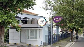 A building with a sign reading "Sans Hotels" and a security booth. - Sans Hotel Fiffa Premiere Malang (Malang)