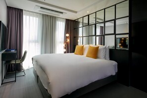 A modern hotel room with a large bed, a desk, and a large window with curtains. - Hotel Alice and Trunk (Jeju City)