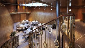 A modern interior with a central dining area, a staircase, and a unique ceiling design. - Fingal A Luxury Floating Hotel (Edinburgh)