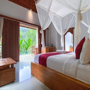 Un dormitorio con cama, mesa y vistas a zonas verdes.