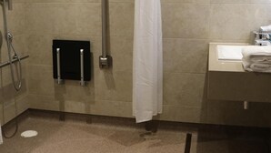 Une salle de bain avec une douche, des toilettes et un lavabo.