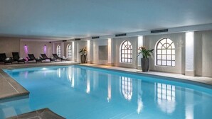 A large indoor swimming pool with lounge chairs and arched windows along the walls. - Brandshatch Place Hotel and Spa (Longfield)
