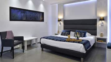 Une chambre d’hôtel moderne avec un grand lit, des lampes de chevet, une table de chevet, une chaise et une œuvre d’art encadrée au mur.