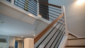 A modern interior with a staircase, a kitchen area, and a dining space. - Modern Oasis in Heart of Fountain Square, 4BR/3BA (Indianapolis)