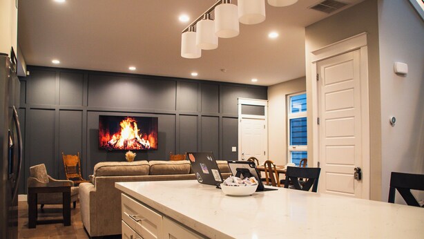 A modern kitchen with a large island, built-in seating, and a flat-screen TV. - Modern Oasis in Heart of Fountain Square, 4BR/3BA (Indianapolis)