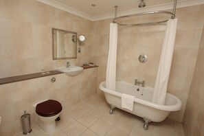 A bathroom with a bathtub, a sink, a toilet, and a mirror. - Classic Lodges Farington Lodge (Leyland)
